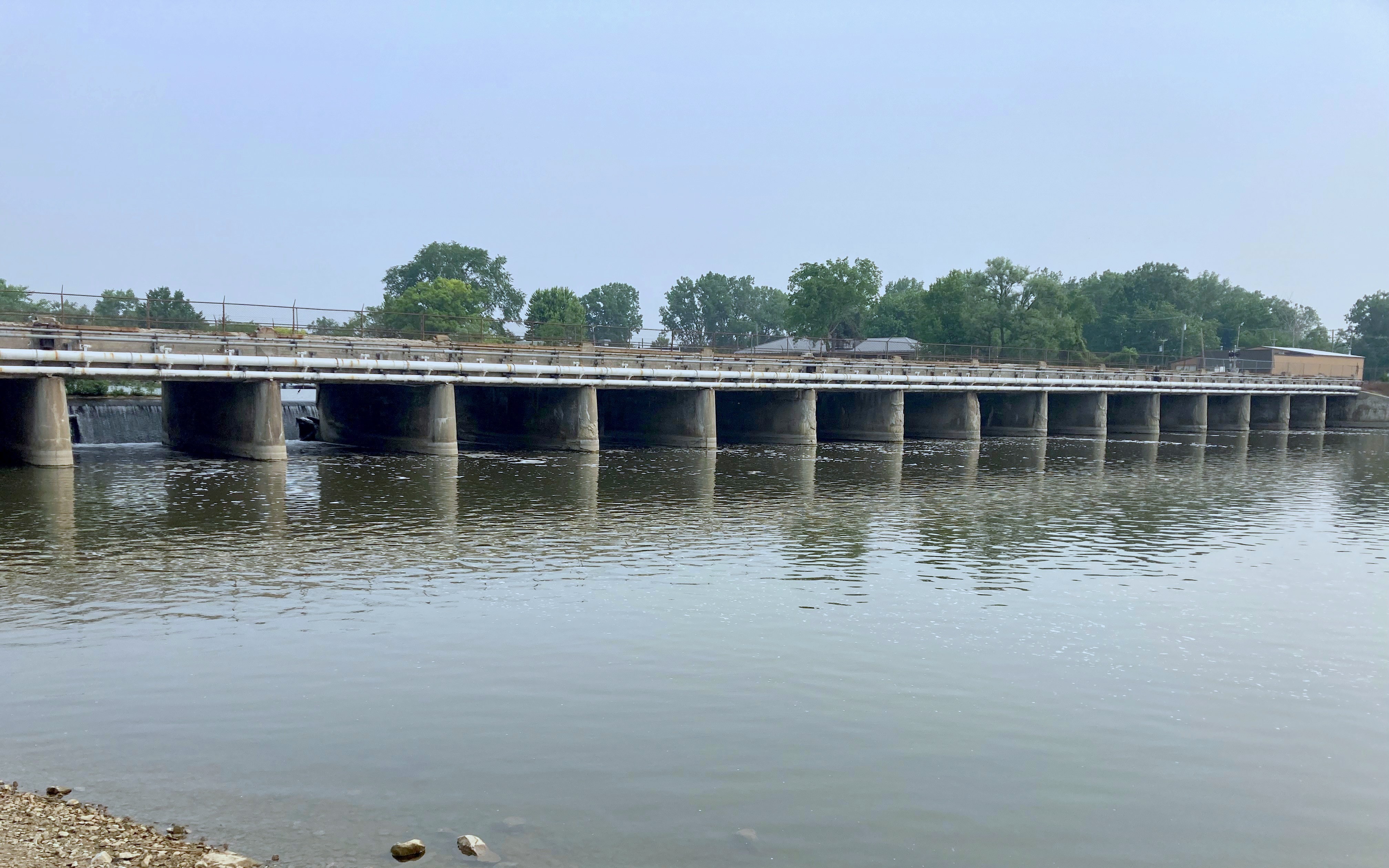 : Photos of two dams that cross large rivers, with transportation structures over the top of each dam.